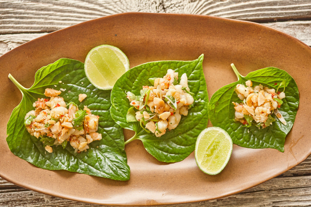 Betel leaves topped with prawns and roasted macadamias